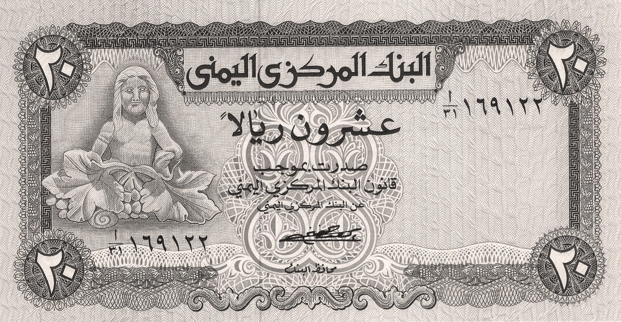 صورة بالأبيض والأسود عن الوجه الأمامي للعملة اليمنية من فئة 20 ريالاً، أصدرها البنك المركزي اليمني بين عامي 1973 و1977. تُظهر الصورة كلمات وأرقاماً باللغة العربية وإطاراً مزخرفاً. يُظهر الجانب الأيسر من الورقة النقدية المصوَّرة قطعة منحوتة مرمرية تحمل تمثالَ ذات مزر (إلهة الخمرة)، وهو تمثال قديم ينتمي لجنوب شبه الجزيرة العربية، ويصوّر إلهة الخصوبة تجلس عارية بين أوراق العنب وعناقيده.
20 ريالاً يمنياً، (وجه العملة الأمامي). جمهورية اليمن، 1973-77،Banknote Index. P-0014. ©  2011 عمر يالشينكايا